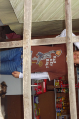 Thomas Arias behind the shop window. His mum has locked him in, for safety, but she's out working a lot and he has no one to talk to. He could hardly speak.